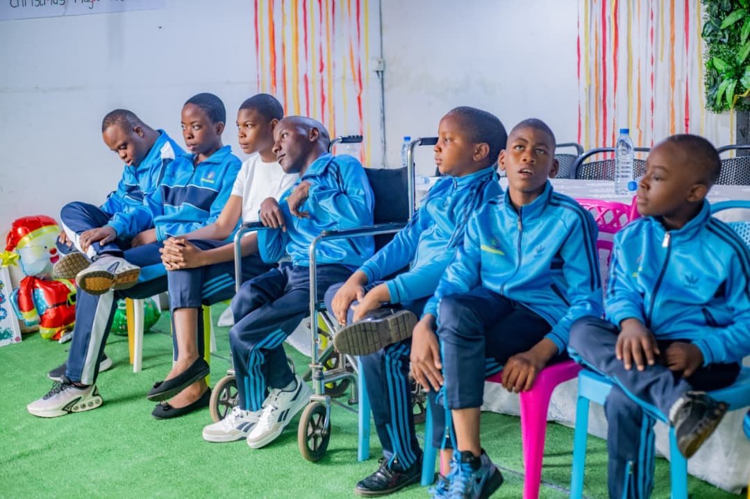 Students in matching blue tracksuits watching the performances
